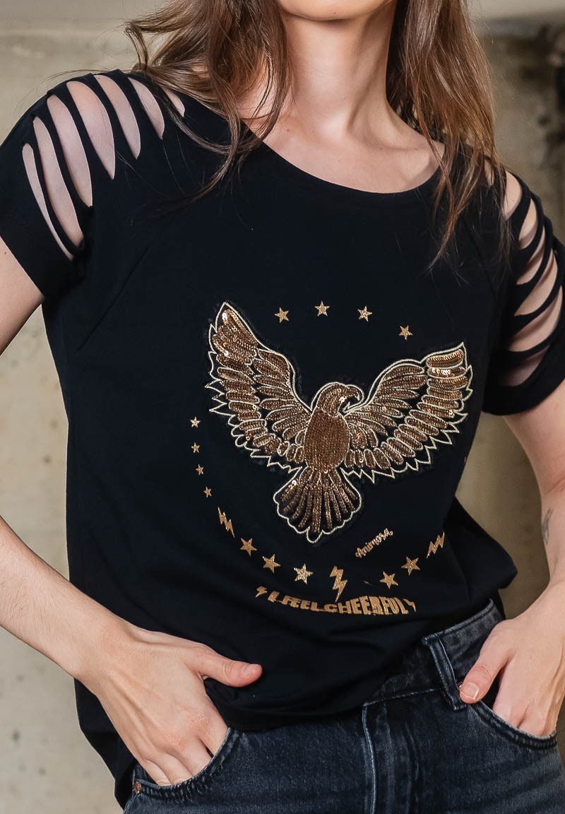 Camiseta negra con aberturas en los hombros y águila de lentejuelas bordada. Detalle águila bordada.