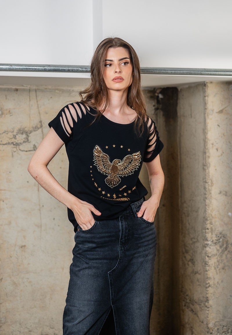 Camiseta negra con aberturas en los hombros y águila de lentejuelas bordada. Plano frontal.