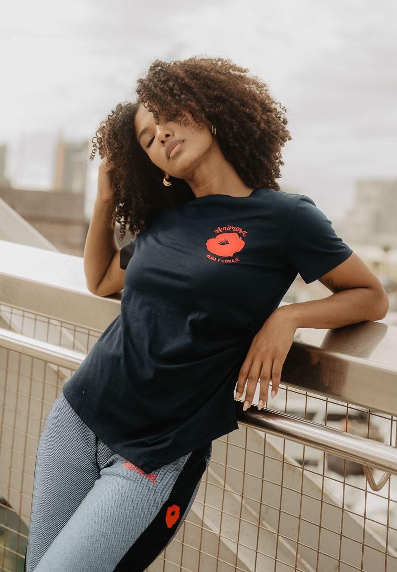 Camiseta negra de manga corta con amapola en el pecho, plano frontal.